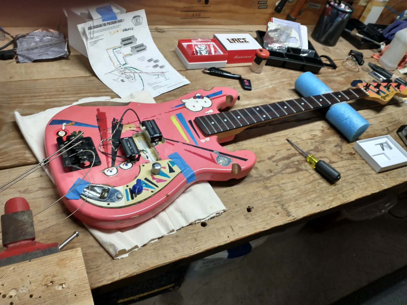 Pink bass guitar mid-surgery — Lace pickup install